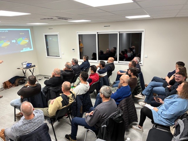 Réunion d’artisans adhérents assistant à une présentation projetée en salle